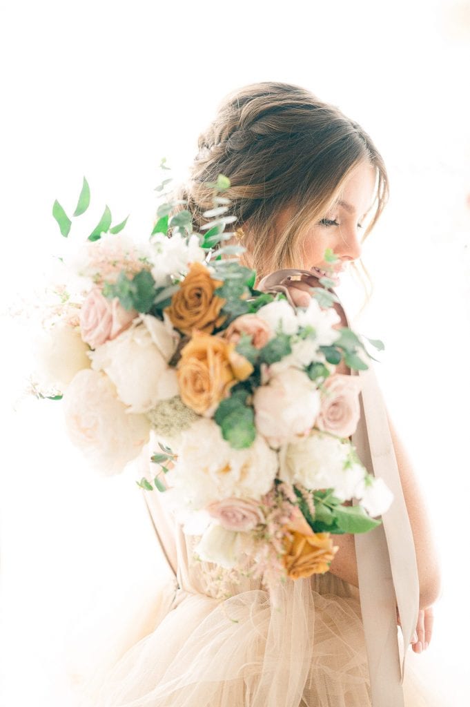 Photo edited by Refined Preset KT Merry of a Beautiful Bride holding a neutral colored bouquet with gold roses.