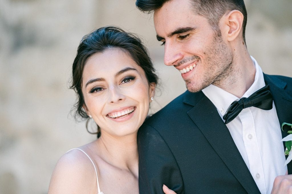 Bride smiling at the camera with groom looking at the bride by Amy Huang Photography a San Diego Wedding Photographer