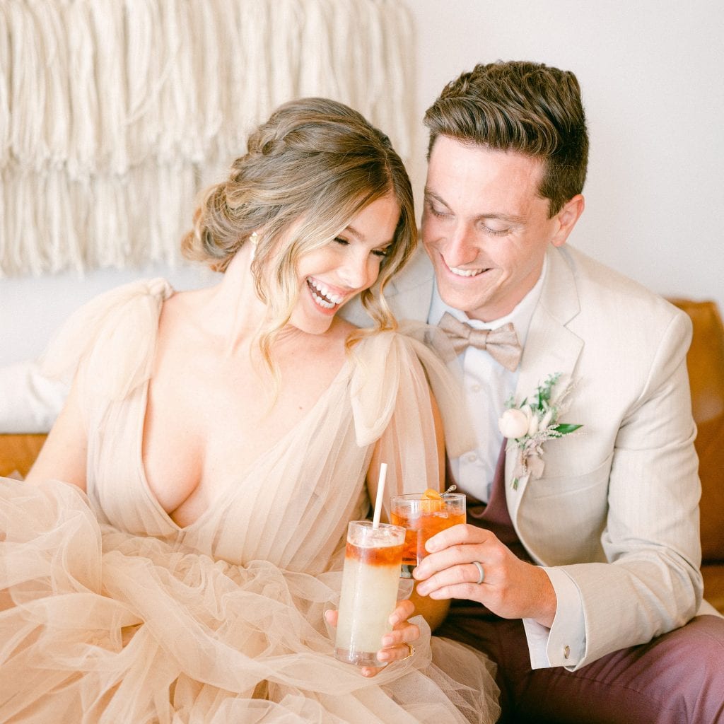 Bride and Groom holding cocktails and laughing and having a great time | a photo by Amy Huang Photography a Wedding Photographer in San Diego