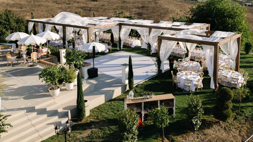 Outdoor wedding reception at Jenue Perche, a European-inspired San Diego wedding venue, featuring elegant decor, scenic hillside views, and refined seating arrangements under draped canopy structures.